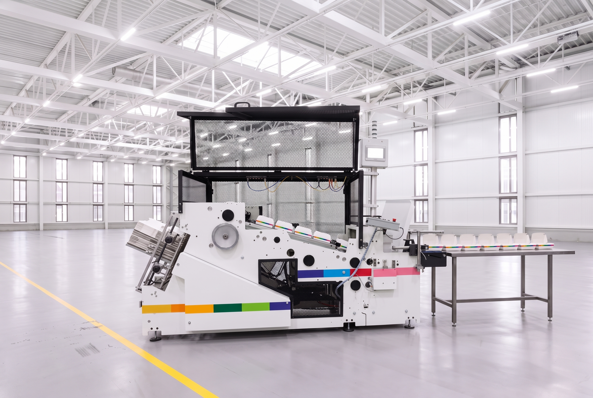 Paperboard forming machine pressing printed board into food trays and clamshells